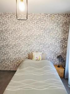 a bedroom with a bed in a room with a wall at Le Tertre Camillac in Saint-Seurin-de-Bourg