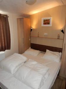 ein Schlafzimmer mit zwei Betten mit weißer Bettwäsche in der Unterkunft J 219 in Petten