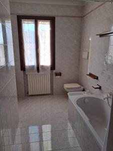 a bathroom with a tub and a toilet and a window at Casa Maria in Valmareno