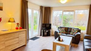 ein Wohnzimmer mit Sofa und Fernseher in der Unterkunft J 228 in Petten