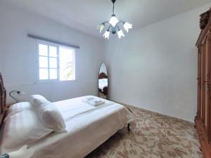 Un dormitorio con una cama y una ventana y una lámpara de araña. en Emelina, en La Guancha 13 fotos más