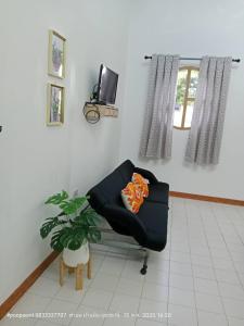 a living room with a black chair and a plant at The pool villa in Ban Phu Din