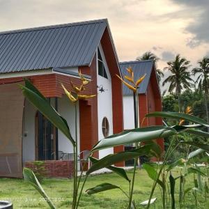 a red and white house with a plant in front of it at The pool villa in Ban Phu Din