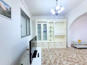 sala de estar con armarios blancos y mesa en Emelina, en La Guancha