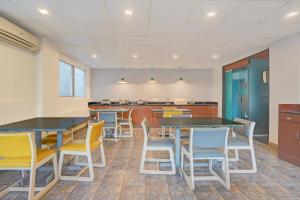 a cafeteria with tables and chairs in a room at FabHotel SLR Residency in Bengaluru +25 photos