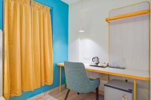 a desk in a room with a yellow curtain at FabHotel SLR Residency in Bengaluru