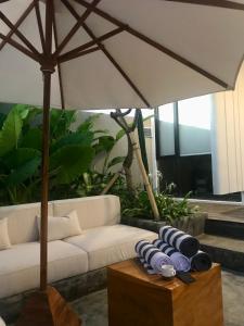 - un salon avec un canapé blanc et un parasol dans l'établissement Sagrada Villa canggu Bali, à Dalung 16 autres photos