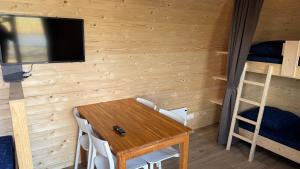 a dining room with a table and a tv and bunk beds at Campervan in Petten +13 photos