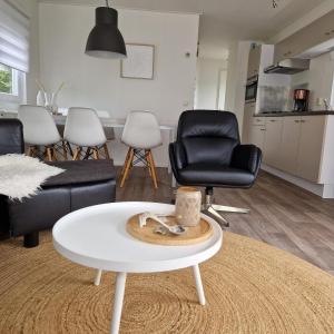 un soggiorno con tavolino bianco e sedie di Chalet 231 a Petten