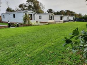 un ampio cortile con una casa sullo sfondo di Chalet 240 a Petten