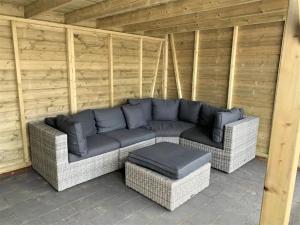a couch and ottoman sitting on a patio at Chalet 240 in Petten +8 photos