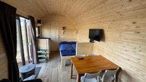 a small room with a table and a bed at Kampeerwagon in Petten