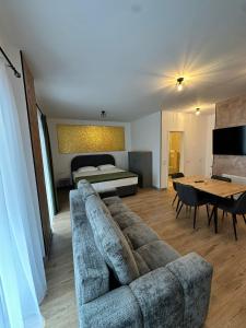 Una sala de estar con un sofá, una cama y una mesa. en FLH - Garden Residence, en Sibiu
