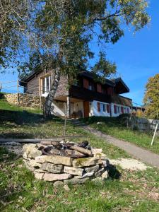 una hoguera de piedra frente a una casa en Le Petit Rêve, en Les Breuleux