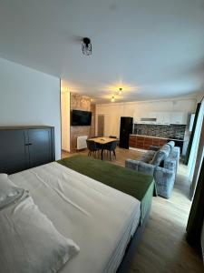 Un dormitorio con una cama grande y una sala de estar. en FLH - Garden Residence, en Sibiu