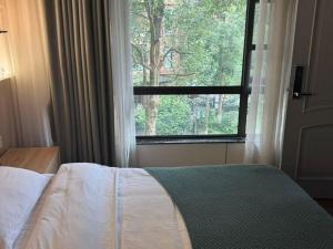 a bedroom with a bed and a large window at Heinemann Hotel Sunny King Room without Bathtub A308 with a jacuzzi and a local in Baoguosi