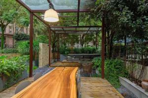 a large wooden table in a garden with a light at Heinemann Hotel Sunny King Room without Bathtub A308 with a jacuzzi and a local in Baoguosi +3 photos