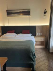 a bedroom with a large bed with red pillows at Heinemann Hotel Sunny King Room without Bathtub B308 with a jacuzzi and a local in Baoguosi