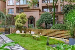 a garden with chairs and tables in front of a building at Heinemann Hotel Sunny King Room without Bathtub B308 with a jacuzzi and a local in Baoguosi