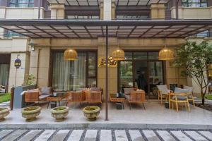 a restaurant with tables and chairs in front of a building at Heinemann Hotel Sunny King Room without Bathtub B308 with a jacuzzi and a local in Baoguosi