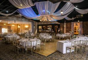a banquet hall with white tables and chairs and a chandelier at Springfort Hall Hotel in Mallow