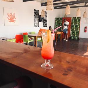 a drink sitting on top of a wooden bar at Blackstone Sands Resort Bilene in Vila Praia Do Bilene