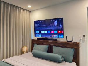 een slaapkamer met een bed en een grote tv aan de muur bij The gallery condominium Ben in Jomtien Beach