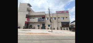 a building on the side of a street with a truck in front at Hotel O R R Comforts Boarding and Lodging in Nelamangala