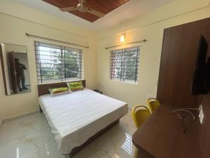 a bedroom with a bed and two windows at Hotel O R R Comforts Boarding and Lodging in Nelamangala