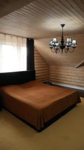 a bedroom with a large bed with a chandelier at Jansaya Resort база отдыха Жансая in Aleksandrovka