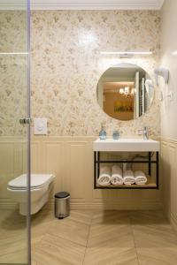 a bathroom with a sink and a toilet and a mirror at Pensiunea Casa Sturza in Bacău