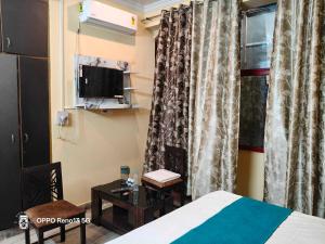 a room with a bed and a table and a window at HOTEL O AWARA GRAND PALACE in Pratāpgarh