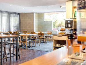 a restaurant with tables and chairs in a cafeteria at Mantra on Northbourne in Canberra