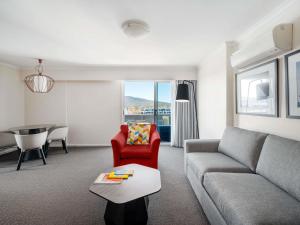 a living room with a couch and a table at Mantra on Northbourne in Canberra