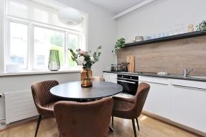a kitchen with a table with chairs and a vase of flowers at LL Properties - H99 Main Street Stay in Akureyri