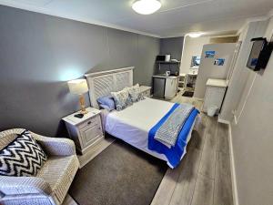 un dormitorio con una cama y un sofá en Hysie oppie see, en Jongensfontein