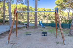 a swing set in a park with trees at Bosmar 1C in Pals