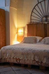 a bedroom with a large bed with a wooden headboard at Novecento Room and Breakfast Puglia in Massafra