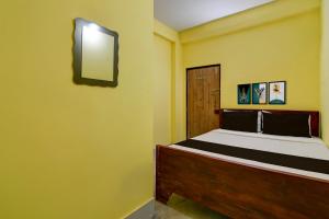 a bedroom with a bed and a mirror on the wall at Hotel O Lila Guest House in Sāntrāgāchi