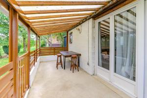 Un porche con una pérgola de madera y una mesa y taburetes. en Gîte de la Sambre - Gîte pour 4p, en Pommereuil 5 fotos más