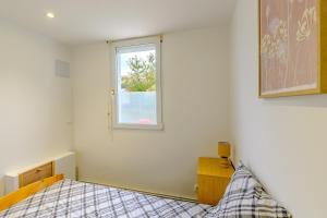 un dormitorio con una cama y una ventana en Gîte de la Sambre - Gîte pour 4p, en Pommereuil