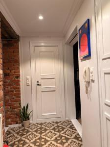 un pasillo con una puerta blanca y una pared de ladrillo en Stylish & Cozy Scandinavian Apartment In The Heart Of Oslo, en Oslo