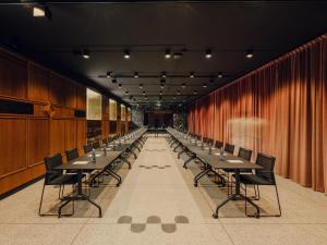 a long row of tables and chairs in a room at Flaner Hotel, WorldHotels Crafted in Warsaw