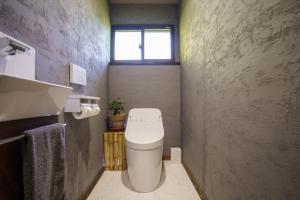 a small bathroom with a toilet and a window at お宿竹あかりOyado Takeakari in Takachiho