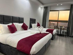 a bedroom with two beds with red and white pillows at The charming view in Wadi Musa