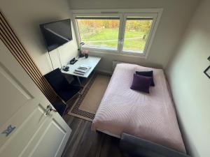 Un dormitorio pequeño con una cama y una ventana. en 2 rooms in 100 sqm apt, en Oslo 6 fotos más