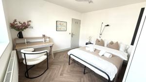 a bedroom with a bed and a desk and a chair at Crystal Palace Stylish Large Ensuite Double Room in Crystal Palace
