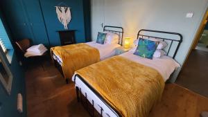 two beds in a room with blue walls at Cosy and comfy 2 bedroom cottage with parking to the rear and a short drive from Cannock town centre in Hednesford