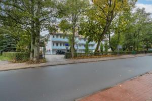 eine leere Straße vor einem weißen Gebäude in der Unterkunft Comfortable Studio for 3 People with Parking in Kołobrzeg by Noclegi Renters in Radzikowo