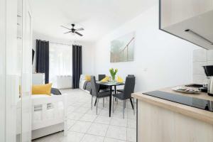 eine Küche und ein Wohnzimmer mit Tisch und Stühlen in der Unterkunft Comfortable Studio for 3 People with Parking in Kołobrzeg by Noclegi Renters in Radzikowo